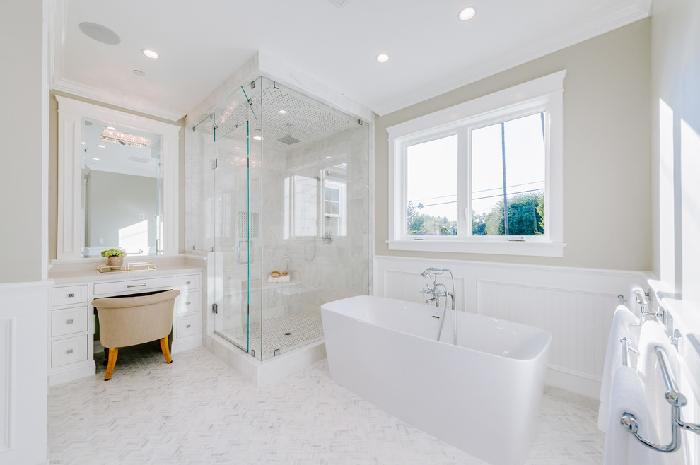 Inredning av ett klassiskt stort en-suite badrum, med luckor med profilerade fronter, vita skåp, ett fristående badkar, våtrum, en toalettstol med separat cisternkåpa, beige väggar, ett undermonterad handfat, bänkskiva i akrylsten och dusch med gångjärnsdörr