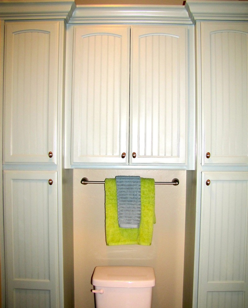 Modelo de cuarto de baño infantil tradicional renovado con armarios con rebordes decorativos, puertas de armario turquesas, sanitario de dos piezas, suelo de baldosas de cerámica y paredes beige