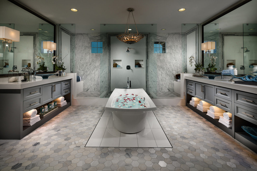 Пример оригинального дизайна: огромная главная ванная комната в стиле неоклассика (современная классика) с серыми фасадами, отдельно стоящей ванной, двойным душем, серой плиткой, плиткой из листового камня, серыми стенами, полом из мозаичной плитки, столешницей из искусственного кварца, серым полом, открытым душем, серой столешницей, фасадами в стиле шейкер, настольной раковиной и окном