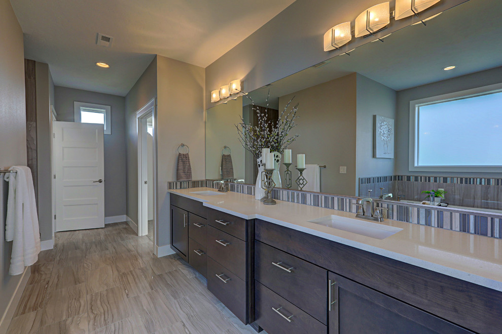 Photo of a large contemporary ensuite bathroom in Seattle with shaker cabinets, dark wood cabinets, a built-in bath, a walk-in shower, a two-piece toilet, grey tiles, porcelain tiles, grey walls, porcelain flooring, a submerged sink, engineered stone worktops, grey floors and an open shower.