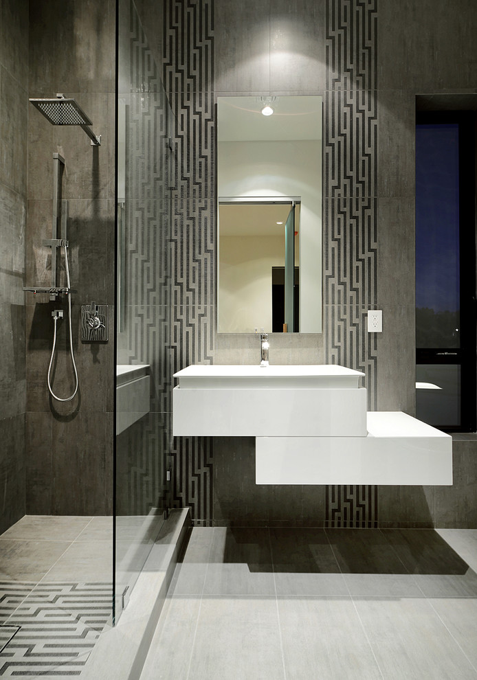 Inspiration för moderna vitt badrum, med ett väggmonterat handfat, vita skåp, en öppen dusch, grå kakel, grå väggar och med dusch som är öppen
