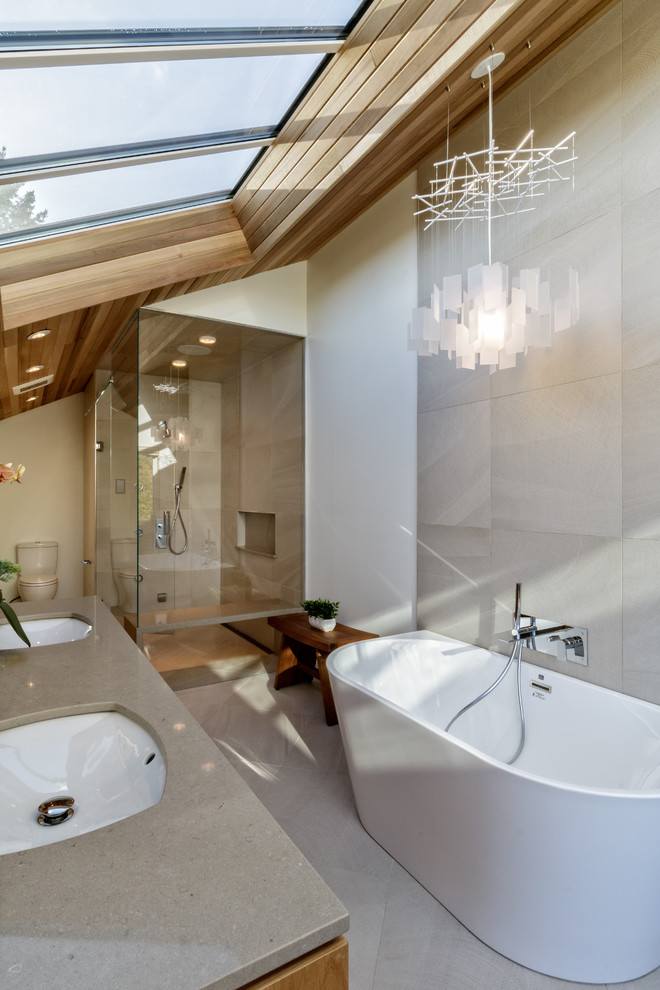 Inspiration for a large contemporary ensuite bathroom in Vancouver with flat-panel cabinets, medium wood cabinets, a freestanding bath, a double shower, a one-piece toilet, grey tiles, cement tiles, white walls, concrete flooring, a submerged sink, concrete worktops, grey floors, a hinged door and grey worktops.