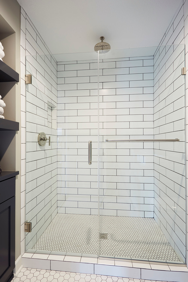 Klassisk inredning av ett litet badrum med dusch, med möbel-liknande, skåp i slitet trä, en dusch i en alkov, vit kakel, grå väggar, klinkergolv i porslin, ett fristående handfat och bänkskiva i akrylsten