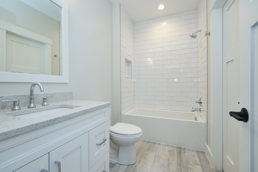 Пример оригинального дизайна: детская ванная комната среднего размера в стиле неоклассика (современная классика) с фасадами в стиле шейкер, белыми фасадами, ванной в нише, душем в нише, раздельным унитазом, керамической плиткой, белыми стенами, полом из керамогранита, врезной раковиной, столешницей из искусственного кварца, серым полом, шторкой для ванной, серой столешницей, нишей, тумбой под одну раковину, встроенной тумбой и белой плиткой