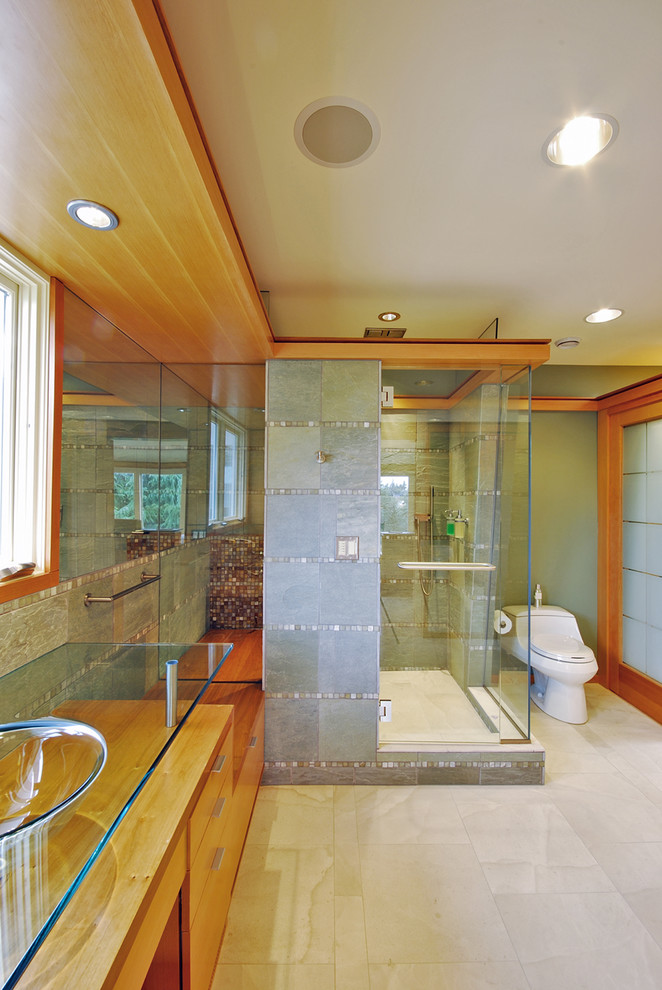 Idéer för ett modernt badrum, med bänkskiva i glas och ett fristående handfat