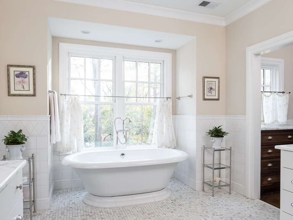 Ispirazione per una stanza da bagno classica con vasca freestanding, piastrelle bianche, pareti beige e pavimento con piastrelle a mosaico