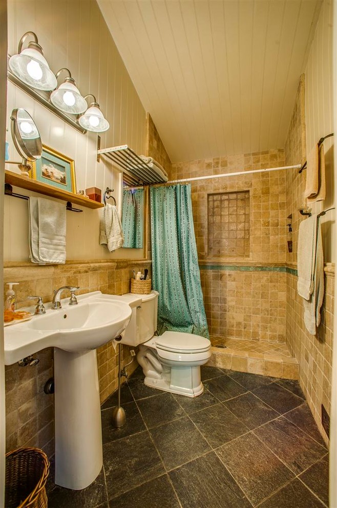 Immagine di una piccola stanza da bagno con doccia con piastrelle beige, piastrelle in pietra, doccia aperta, WC a due pezzi, lavabo a colonna, pareti beige e pavimento in ardesia