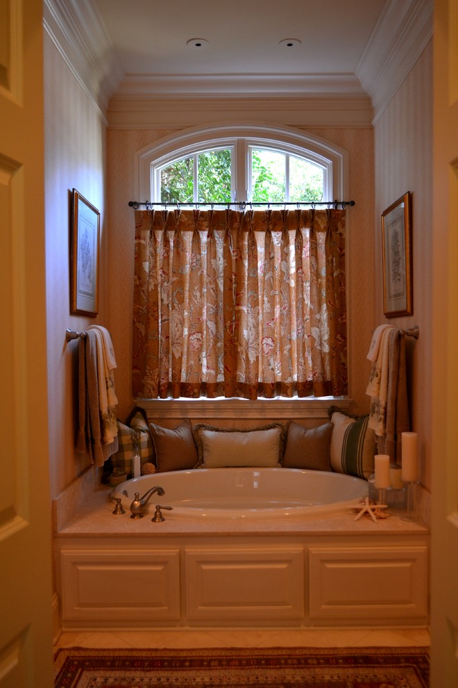 ナッシュビルにあるお手頃価格の小さなトラディショナルスタイルのおしゃれなマスターバスルーム (レイズドパネル扉のキャビネット、白いキャビネット、ドロップイン型浴槽、分離型トイレ、ベージュの壁、トラバーチンの床) の写真