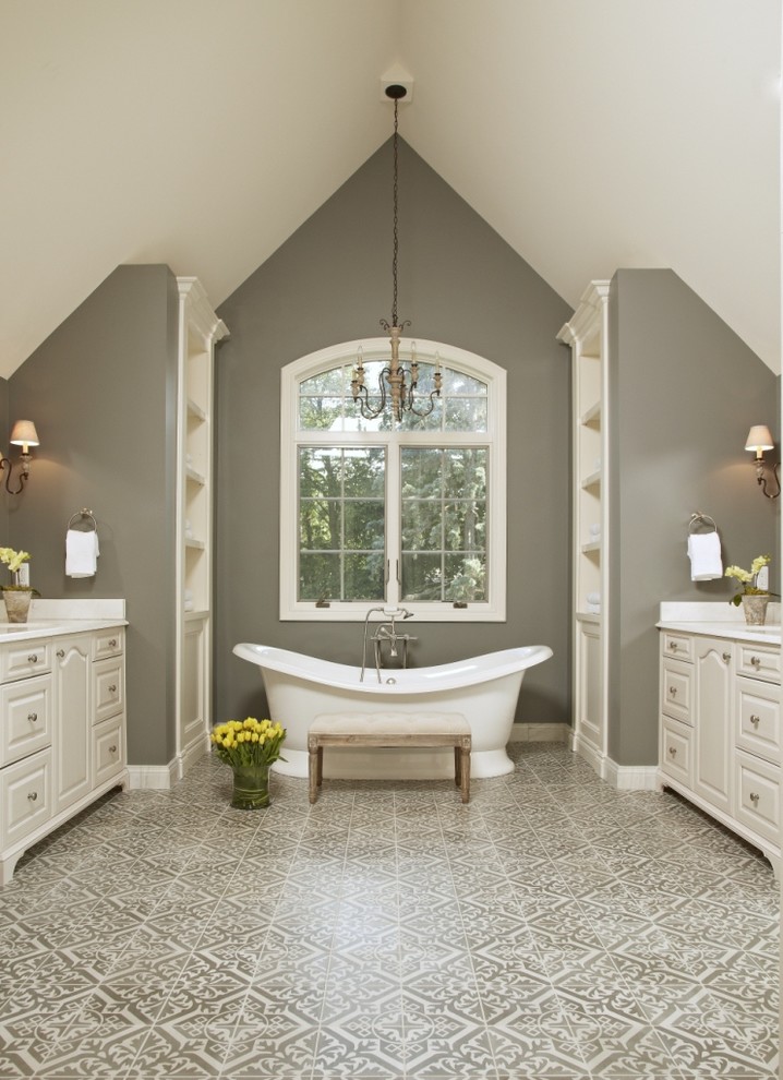 Exempel på ett klassiskt badrum, med luckor med upphöjd panel, vita skåp, ett fristående badkar, grå kakel, vit kakel och grå väggar