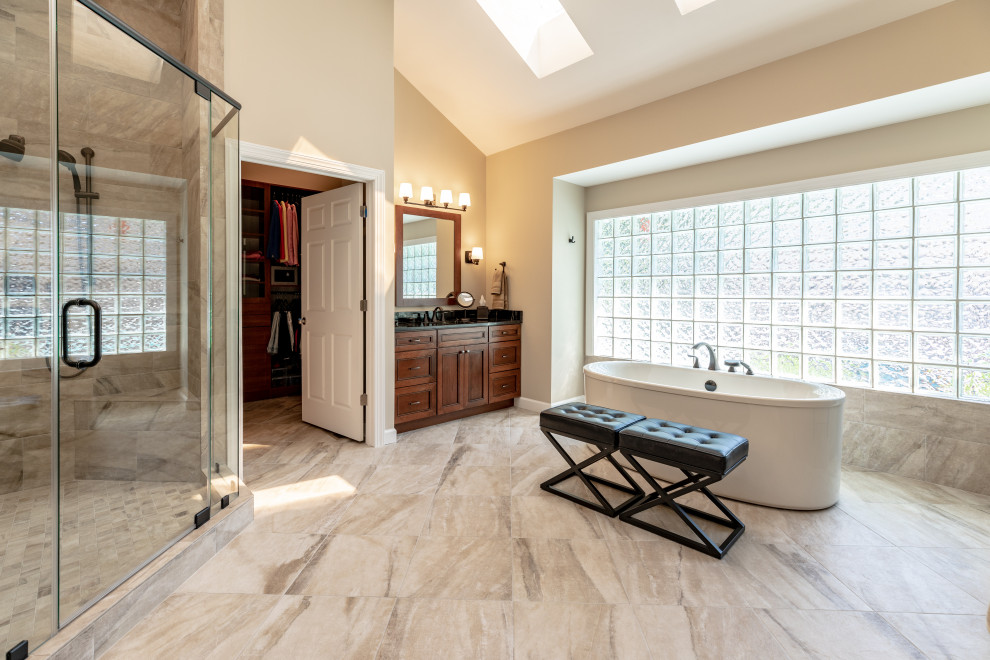 Diseño de cuarto de baño principal actual de tamaño medio con ducha esquinera, baldosas y/o azulejos beige, paredes beige, suelo beige, ducha con puerta con bisagras y encimeras negras