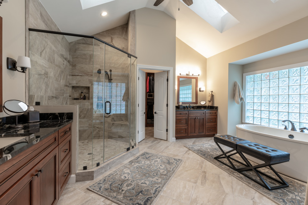 Modelo de cuarto de baño principal contemporáneo de tamaño medio con ducha esquinera, baldosas y/o azulejos beige, paredes beige, suelo beige, ducha con puerta con bisagras y encimeras negras