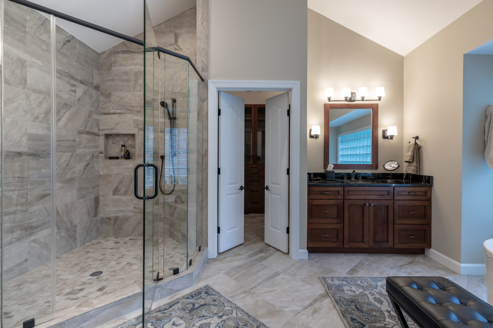 Foto de cuarto de baño principal actual de tamaño medio con ducha esquinera, baldosas y/o azulejos beige, paredes beige, suelo beige, ducha con puerta con bisagras y encimeras negras