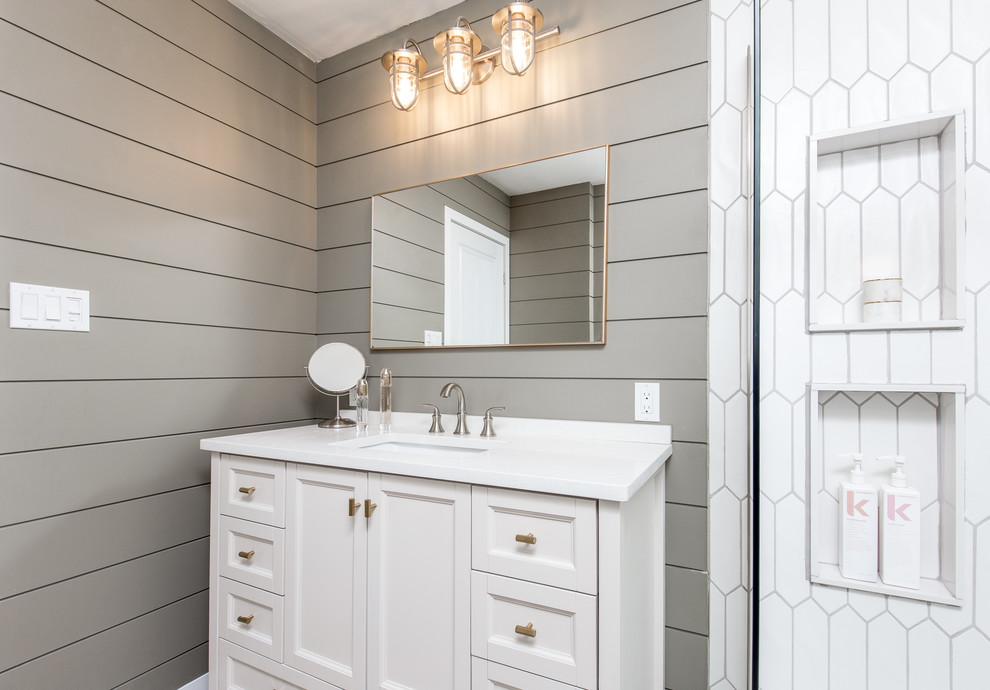Aménagement d'une salle de bain moderne avec une douche d'angle, un carrelage blanc, des carreaux de porcelaine, un mur gris, un lavabo encastré, un plan de toilette en quartz, un sol marron et une cabine de douche à porte coulissante.