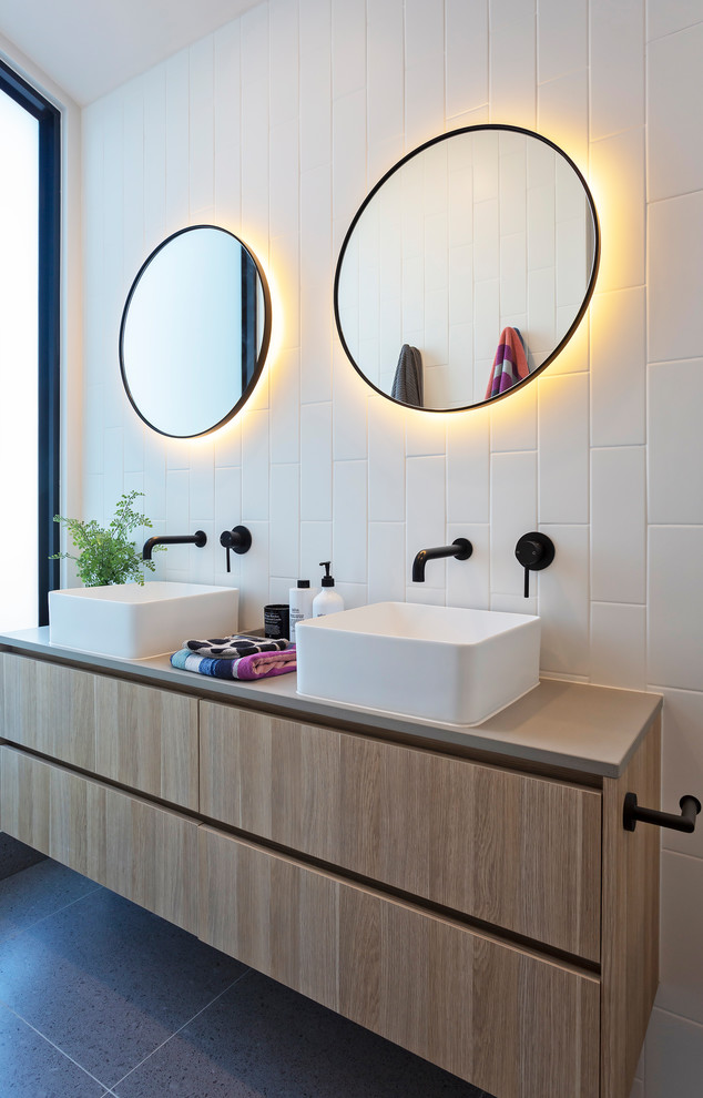 This is an example of a medium sized contemporary shower room bathroom in Melbourne with freestanding cabinets, a one-piece toilet, white tiles, ceramic tiles, white walls, porcelain flooring, a console sink, terrazzo worktops, grey floors, a hinged door and grey worktops.