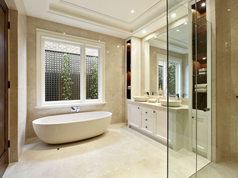 Large mediterranean ensuite bathroom in Melbourne with beaded cabinets, beige cabinets, a freestanding bath, a double shower, a one-piece toilet, beige tiles, stone tiles, beige walls, marble flooring, a vessel sink and marble worktops.