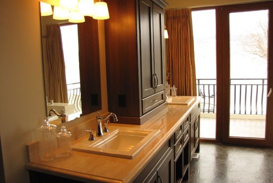 Пример оригинального дизайна: главная ванная комната среднего размера в средиземноморском стиле с фасадами в стиле шейкер, темными деревянными фасадами, бежевыми стенами, полом из керамической плитки, накладной раковиной, столешницей из известняка и коричневым полом