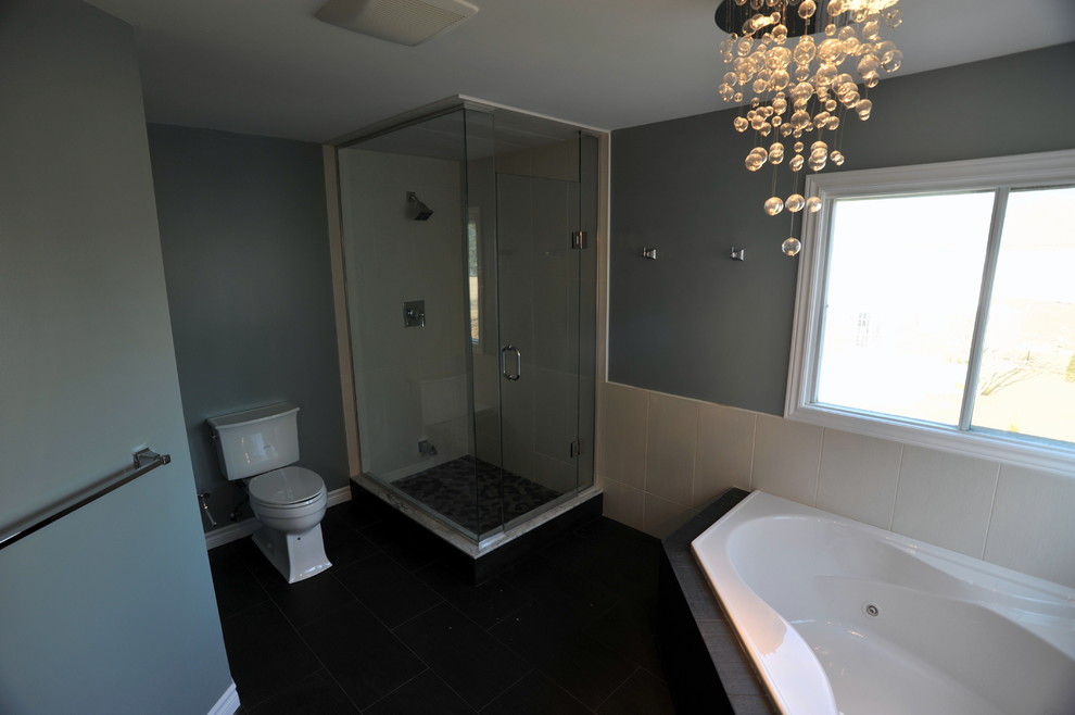 Immagine di una stanza da bagno contemporanea con vasca ad angolo, doccia ad angolo e piastrelle nere
