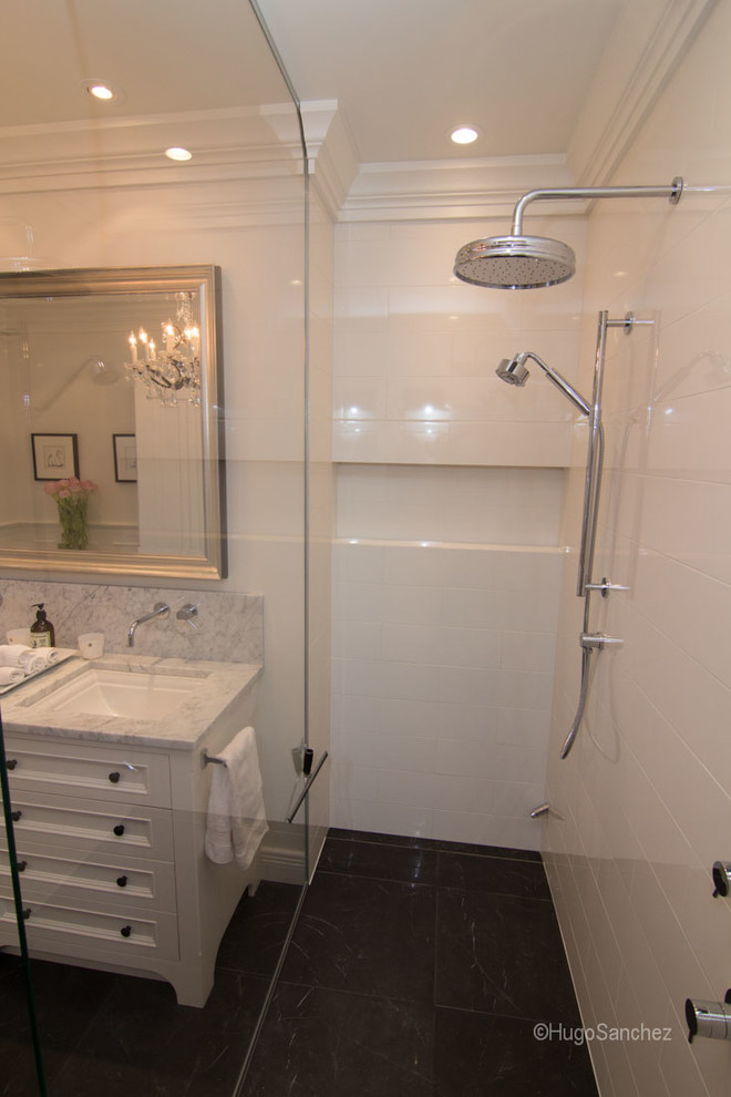 Bild på ett stort vintage en-suite badrum, med marmorbänkskiva, en kantlös dusch, en toalettstol med hel cisternkåpa, svart kakel, porslinskakel, vita väggar och klinkergolv i porslin