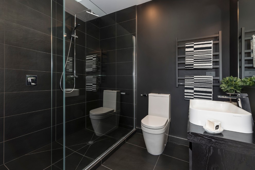 Großes Modernes Badezimmer mit schwarzen Schränken, Doppeldusche, Steinfliesen, weißer Wandfarbe, Aufsatzwaschbecken, freistehender Badewanne und schwarz-weißen Fliesen in Wellington