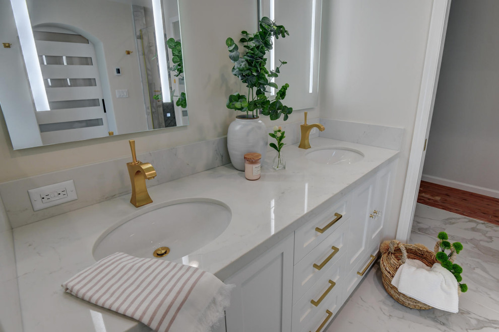 Inspiration pour une grande salle de bain principale design avec un placard à porte shaker, des portes de placard blanches, une baignoire encastrée, une douche d'angle, WC à poser, un carrelage blanc, un carrelage en pâte de verre, un mur blanc, un sol en marbre, un lavabo encastré, un plan de toilette en surface solide, un sol blanc, une cabine de douche à porte battante, un plan de toilette gris, meuble double vasque et meuble-lavabo encastré.