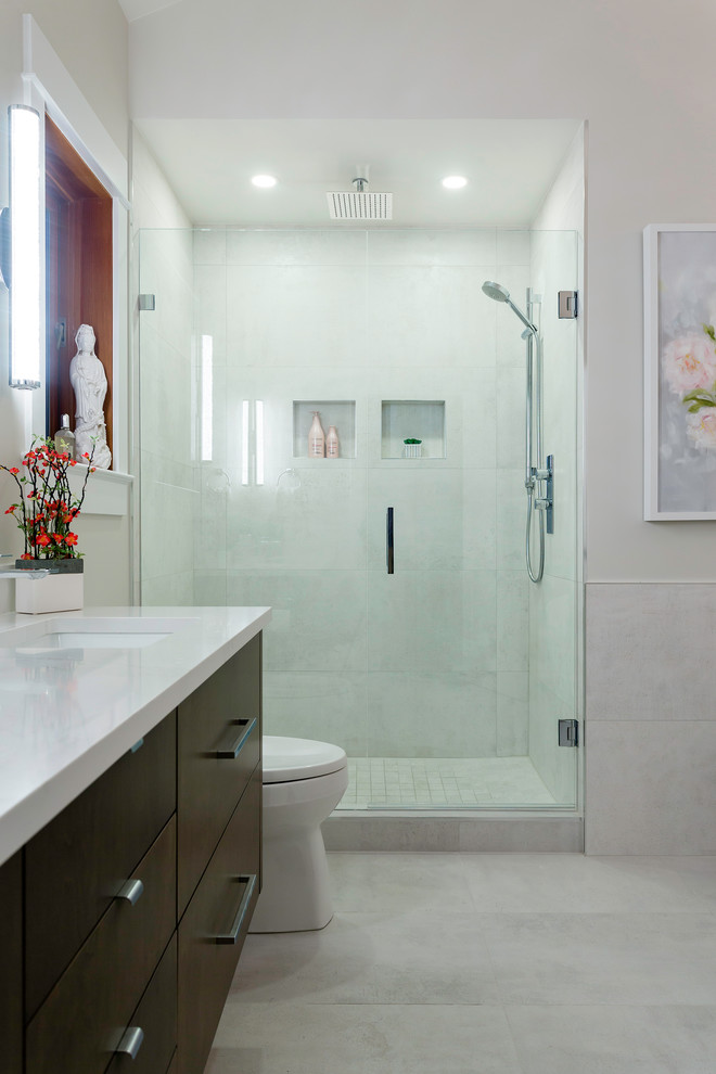 Bathroom - large contemporary master gray tile and porcelain tile porcelain tile and gray floor bathroom idea in Vancouver with flat-panel cabinets, brown cabinets, a two-piece toilet, white walls, an undermount sink, quartz countertops and a hinged shower door
