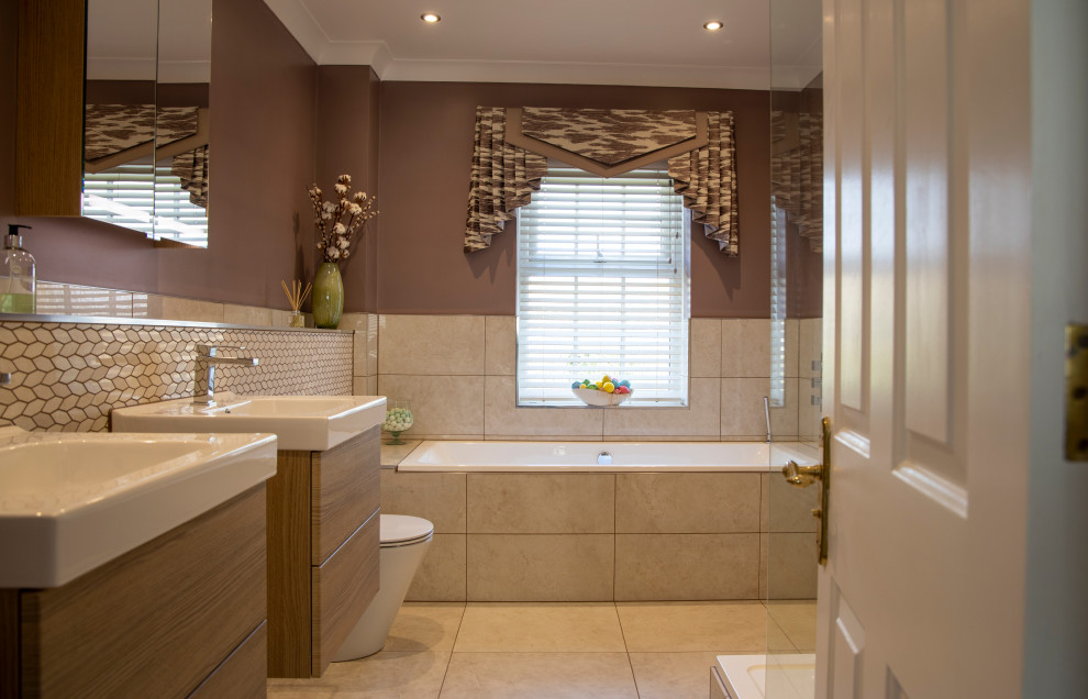 Пример оригинального дизайна: главная ванная комната среднего размера в стиле неоклассика (современная классика) с плоскими фасадами, коричневыми фасадами, ванной в нише, открытым душем, унитазом-моноблоком, бежевой плиткой, керамогранитной плиткой, фиолетовыми стенами, полом из керамогранита, подвесной раковиной, бежевым полом и открытым душем