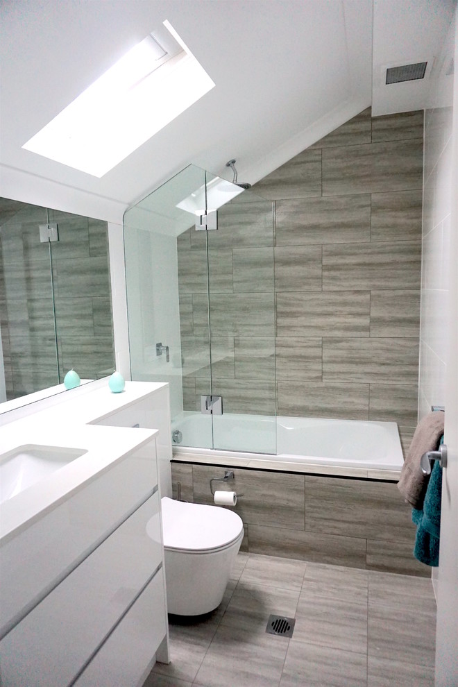Inspiration för små moderna badrum, med släta luckor, vita skåp, ett platsbyggt badkar, en vägghängd toalettstol, porslinskakel, vita väggar, bänkskiva i kvarts, ett undermonterad handfat, en kantlös dusch, vit kakel och klinkergolv i keramik