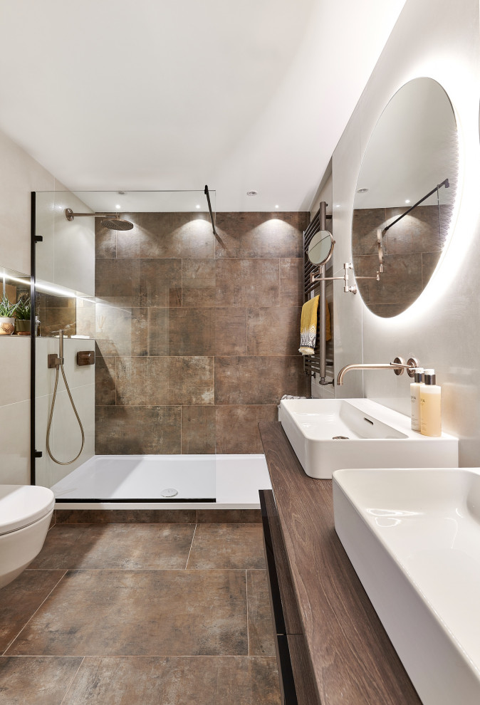 Стильный дизайн: главная ванная комната среднего размера в стиле модернизм с открытыми фасадами, темными деревянными фасадами, открытым душем, инсталляцией, коричневой плиткой, керамогранитной плиткой, бежевыми стенами, полом из керамогранита, коричневым полом и открытым душем - последний тренд