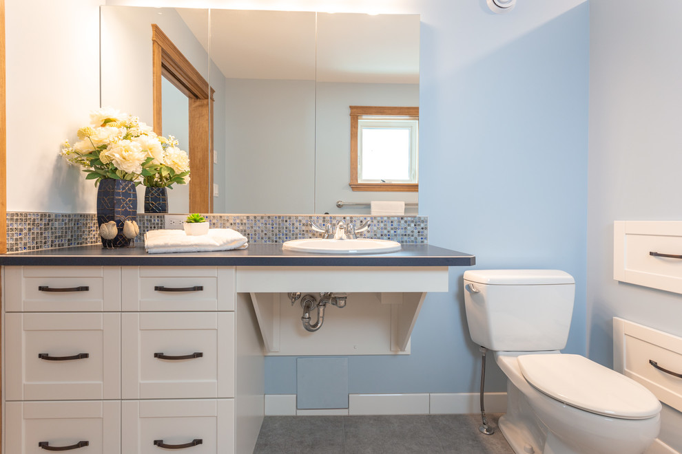 This is an example of a medium sized traditional ensuite bathroom in Other with white walls, medium hardwood flooring, brown floors, recessed-panel cabinets, white cabinets, a walk-in shower, a two-piece toilet, blue tiles, mosaic tiles, a built-in sink, laminate worktops and blue worktops.