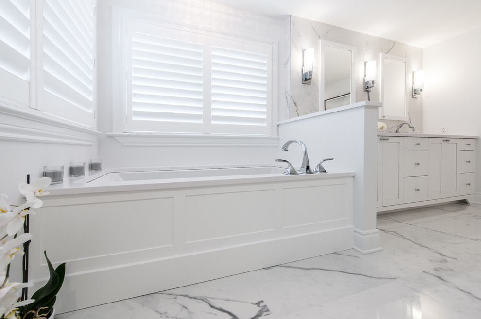 Inspiration for a medium sized classic ensuite bathroom in Ottawa with shaker cabinets, white cabinets, a submerged bath, a built-in shower, white tiles, porcelain tiles, white walls, porcelain flooring, a submerged sink, engineered stone worktops, white floors and a hinged door.