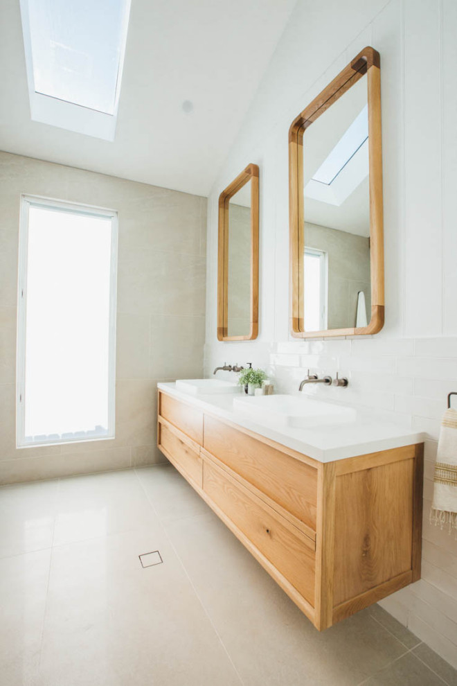 Modern inredning av ett stort vit vitt en-suite badrum, med skåp i shakerstil, skåp i ljust trä, beige kakel, porslinskakel, klinkergolv i porslin, ett fristående handfat och beiget golv