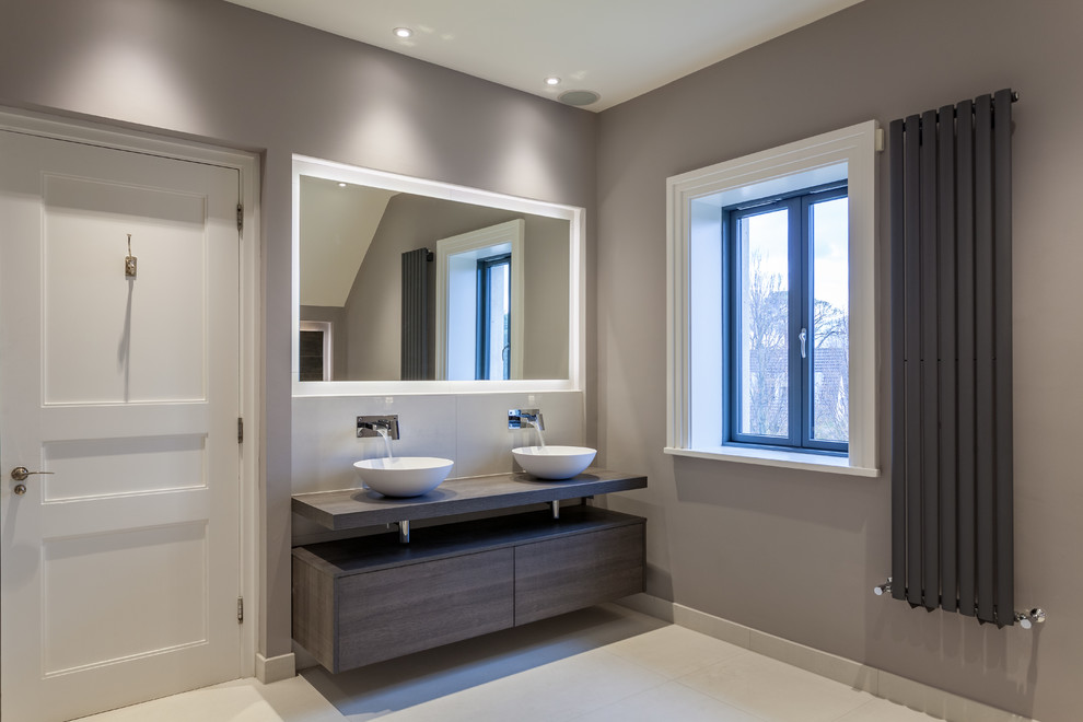 Idée de décoration pour une salle de bain design en bois foncé avec un placard à porte plane, un mur gris, un sol en carrelage de porcelaine et un sol blanc.