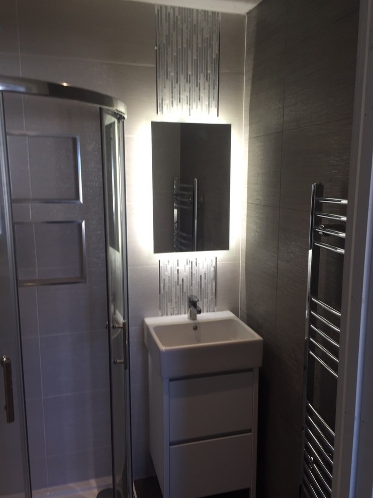 Modernes Badezimmer En Suite mit verzierten Schränken, weißen Schränken, Eckdusche, Wandtoilette, beigen Fliesen, Keramikfliesen, beiger Wandfarbe, Keramikboden und Waschtischkonsole in Dublin