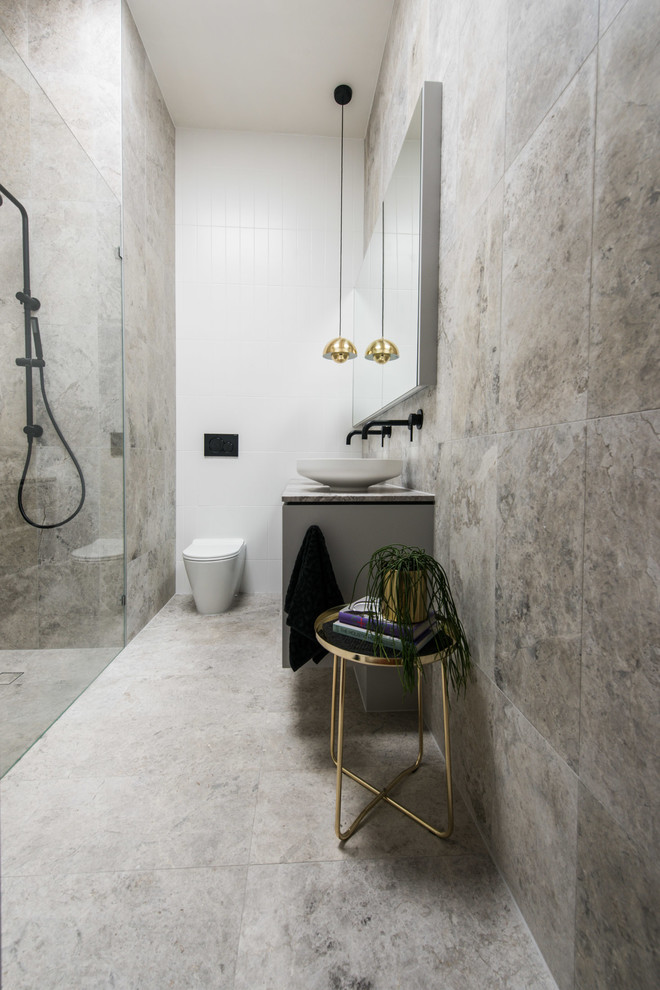 На фото: главная ванная комната среднего размера в современном стиле с фасадами островного типа, серыми фасадами, отдельно стоящей ванной, открытым душем, унитазом-моноблоком, белой плиткой, мраморной плиткой, серыми стенами, мраморным полом, настольной раковиной, мраморной столешницей, серым полом и душем с распашными дверями с