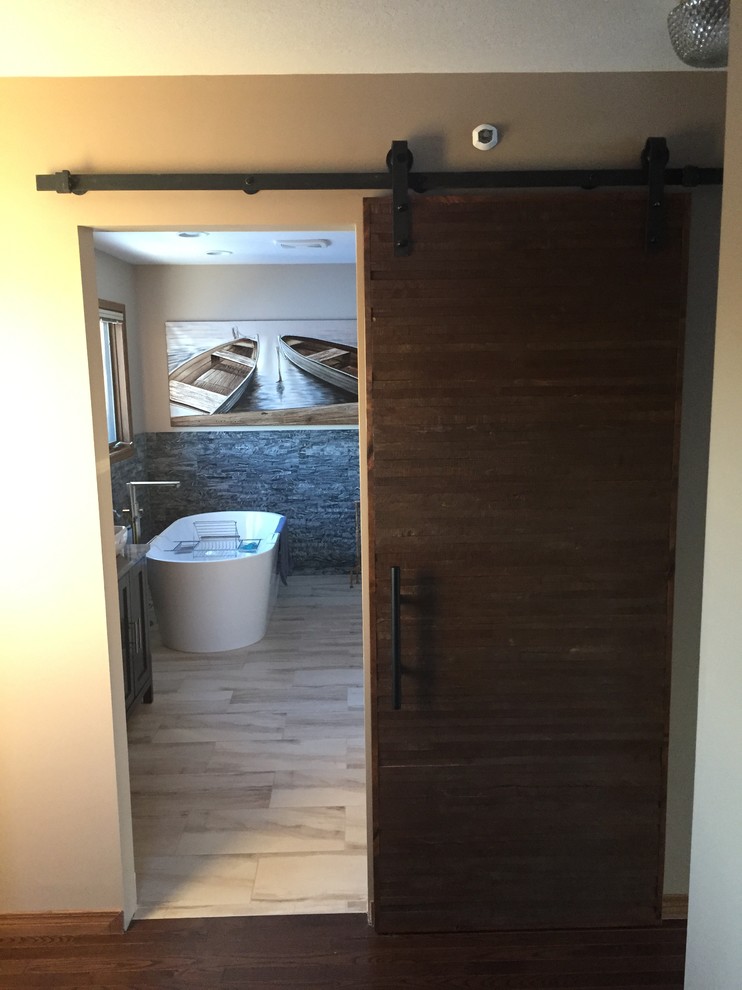 Photo of a large modern ensuite bathroom in Calgary with shaker cabinets, dark wood cabinets, a freestanding bath, a corner shower, beige walls, a vessel sink and granite worktops.