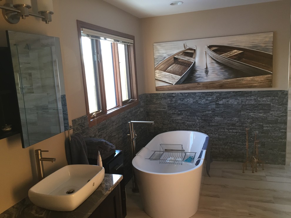 На фото: большая главная ванная комната в стиле модернизм с отдельно стоящей ванной, угловым душем, бежевыми стенами, настольной раковиной, столешницей из гранита, фасадами в стиле шейкер и темными деревянными фасадами с