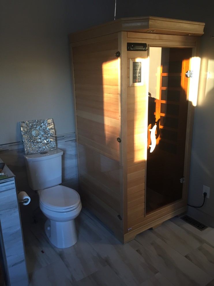 Immagine di una grande sauna moderna con ante in stile shaker, ante in legno bruno, vasca freestanding, doccia ad angolo, pareti beige, lavabo a bacinella e top in granito