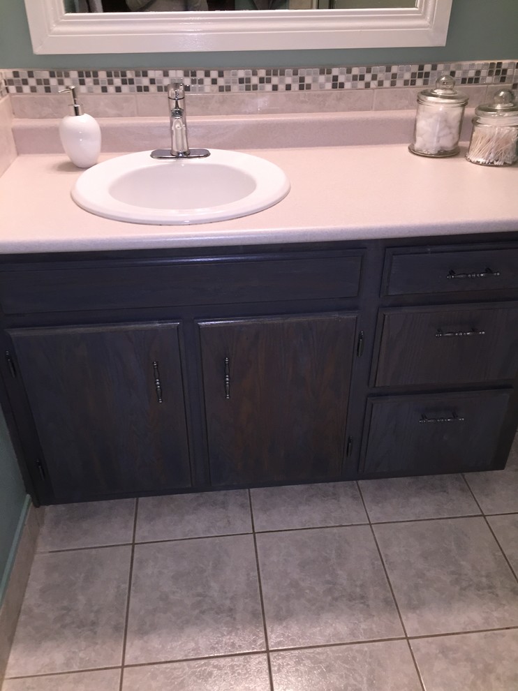 Photo of a medium sized modern shower room bathroom in Calgary with a built-in sink, raised-panel cabinets, grey cabinets, laminate worktops, a corner shower, a two-piece toilet, multi-coloured tiles, glass sheet walls, blue walls and ceramic flooring.