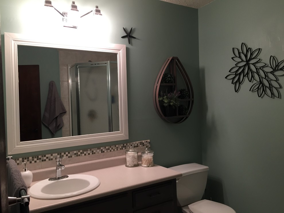 Mittelgroßes Modernes Duschbad mit Einbauwaschbecken, profilierten Schrankfronten, grauen Schränken, Laminat-Waschtisch, Eckdusche, Wandtoilette mit Spülkasten, farbigen Fliesen, Fliesen aus Glasscheiben, blauer Wandfarbe und Keramikboden in Calgary