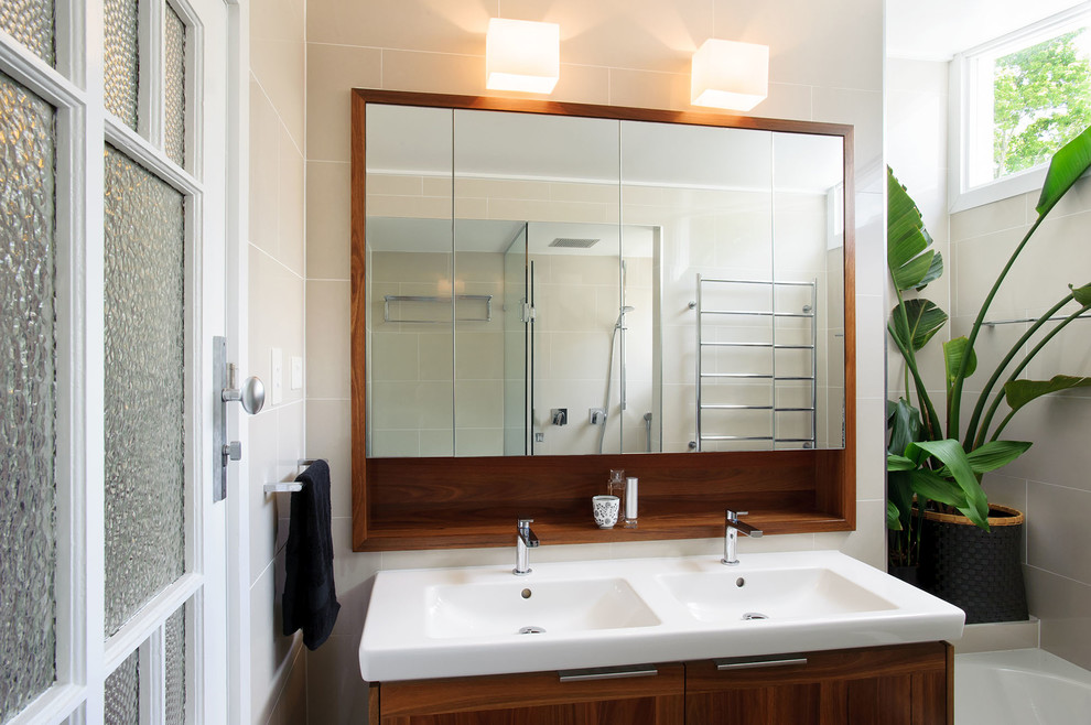 Small contemporary ensuite bathroom in Brisbane with freestanding cabinets, medium wood cabinets, a built-in bath, a double shower, beige tiles, ceramic tiles, solid surface worktops, a hinged door, a one-piece toilet, ceramic flooring, an integrated sink and green floors.