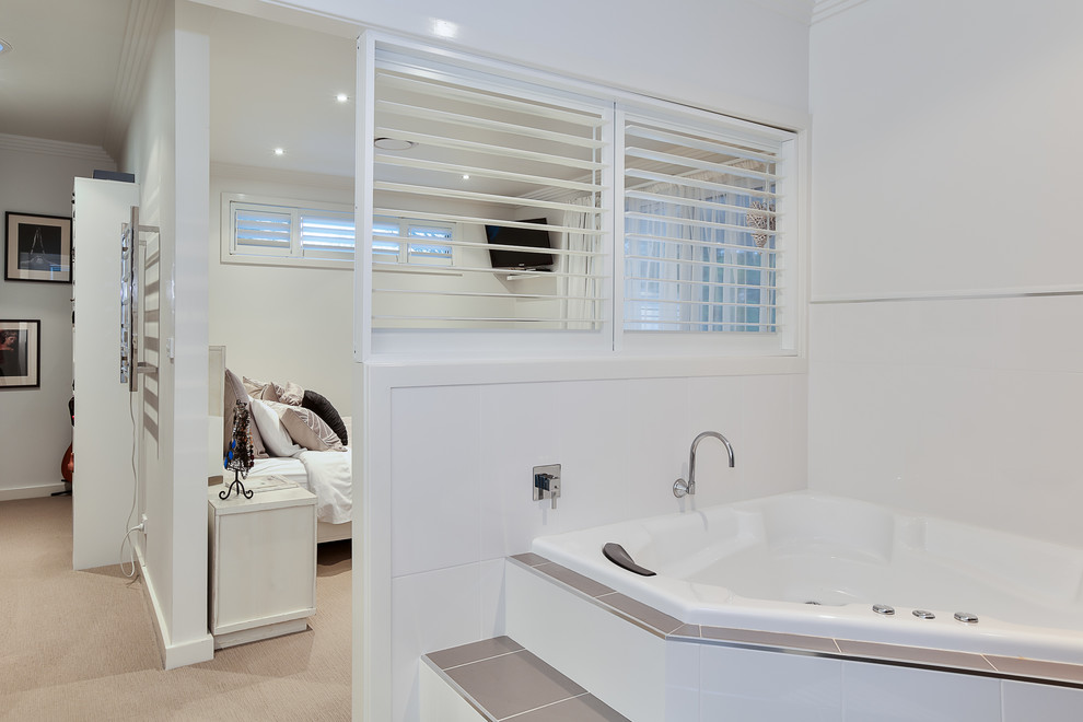 Idee per una stanza da bagno padronale design di medie dimensioni con vasca ad angolo, piastrelle bianche, piastrelle in ceramica, pareti bianche, pavimento in cementine e pavimento marrone