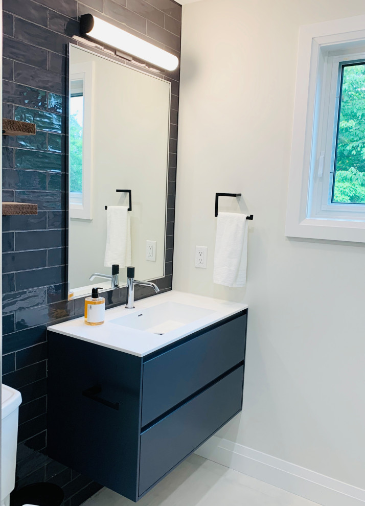 Medium sized contemporary shower room bathroom in Toronto with flat-panel cabinets, grey cabinets, a built-in shower, a two-piece toilet, grey tiles, porcelain tiles, grey walls, porcelain flooring, an integrated sink, grey floors, a sliding door, white worktops, a wall niche, a single sink and a floating vanity unit.