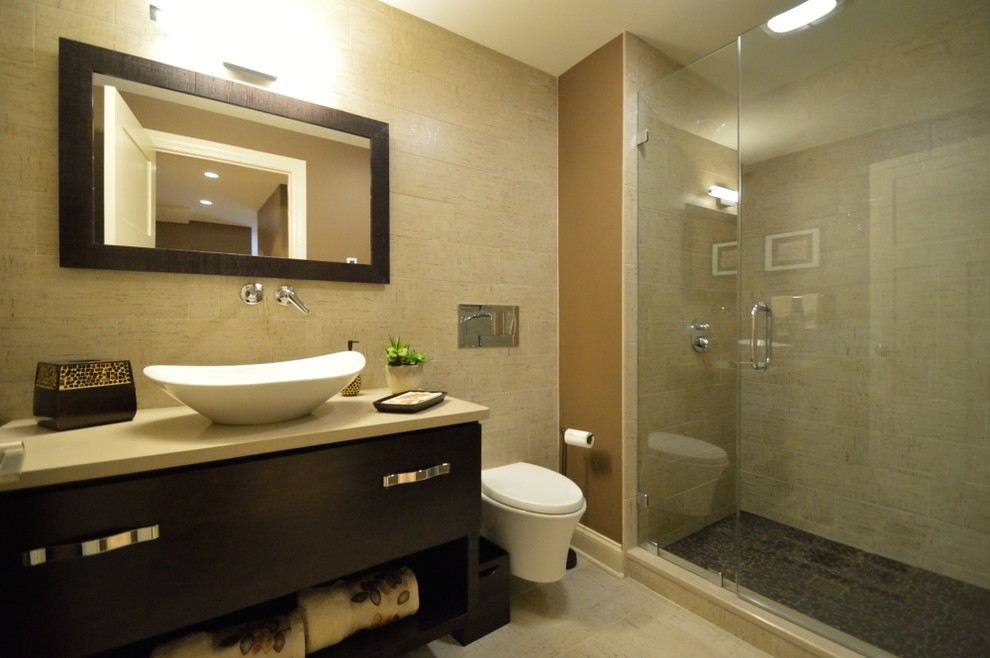 Modern inredning av ett mellanstort badrum, med släta luckor, skåp i mörkt trä, en vägghängd toalettstol, beige kakel, keramikplattor, bruna väggar, klinkergolv i keramik, ett fristående handfat och bänkskiva i kvarts