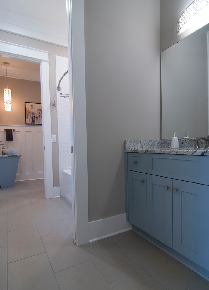 Idées déco pour une grande salle de bain principale contemporaine avec un placard à porte shaker, WC séparés, un carrelage blanc, un sol en carrelage de céramique, un plan de toilette en marbre, un sol blanc, une cabine de douche à porte battante, des portes de placard bleues, une baignoire en alcôve, un combiné douche/baignoire, un carrelage métro, un mur beige et un lavabo encastré.