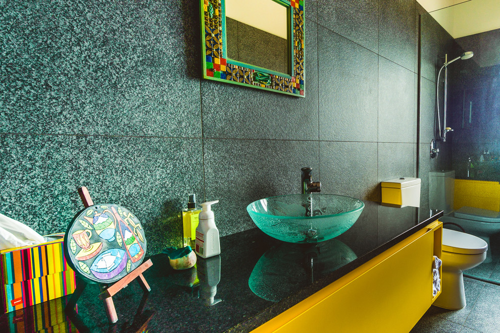 Trendy corner shower photo in Auckland with flat-panel cabinets, yellow cabinets, a two-piece toilet and solid surface countertops