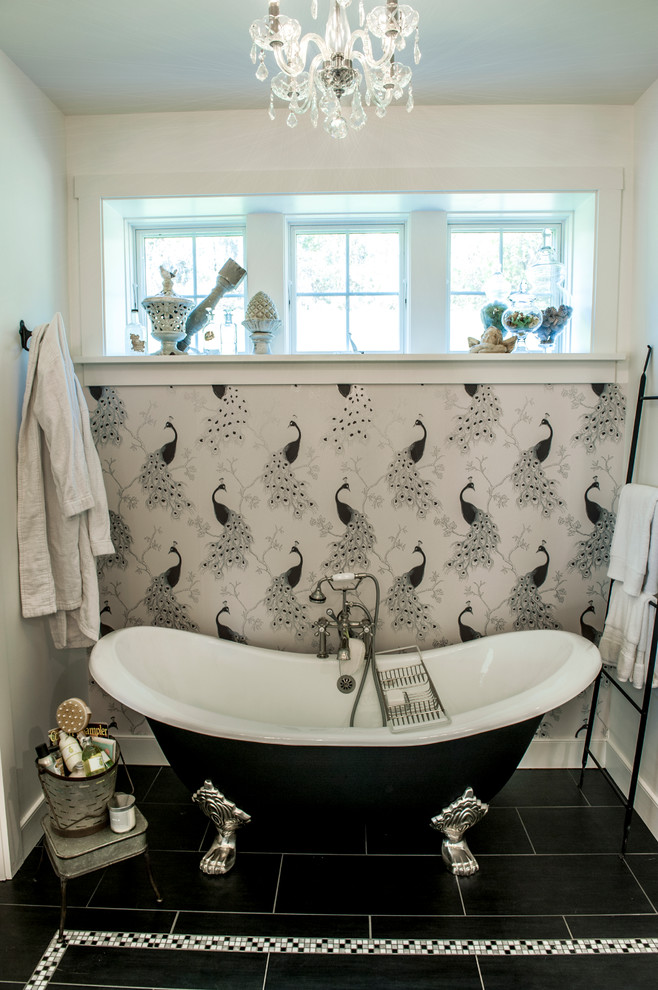 Idées déco pour une salle de bain principale campagne de taille moyenne avec une baignoire sur pieds, un mur blanc et un sol noir.