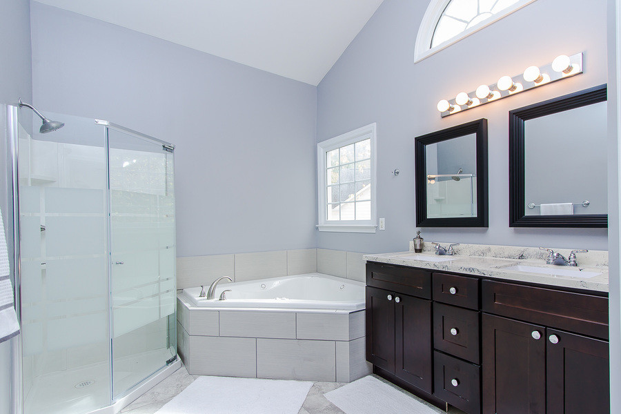 Foto de cuarto de baño principal tradicional renovado de tamaño medio con armarios estilo shaker, puertas de armario marrones, bañera esquinera, ducha esquinera, paredes púrpuras y lavabo bajoencimera