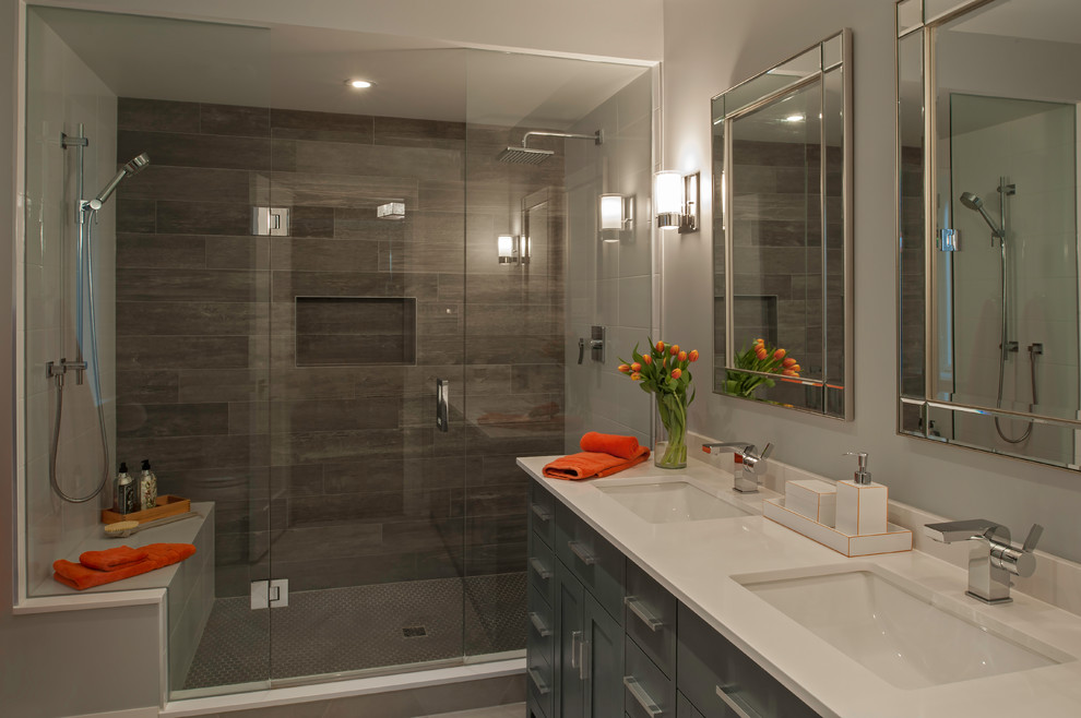 Idéer för att renovera ett mellanstort funkis en-suite badrum, med släta luckor, grå skåp, en dubbeldusch, en toalettstol med hel cisternkåpa, brun kakel, keramikplattor, grå väggar, cementgolv, ett integrerad handfat, bänkskiva i kvarts, grått golv och dusch med gångjärnsdörr