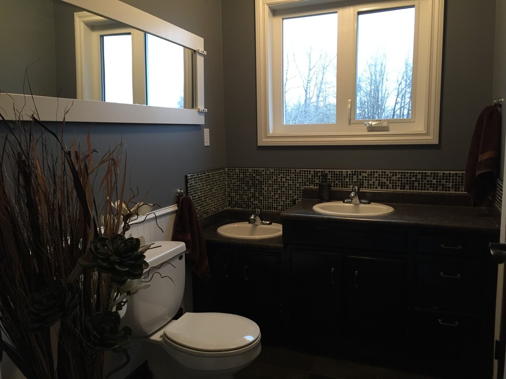 Mittelgroßes Modernes Duschbad mit Einbauwaschbecken, profilierten Schrankfronten, schwarzen Schränken, Laminat-Waschtisch, Wandtoilette mit Spülkasten, farbigen Fliesen, Fliesen aus Glasscheiben, blauer Wandfarbe, Keramikboden und Eckdusche in Calgary