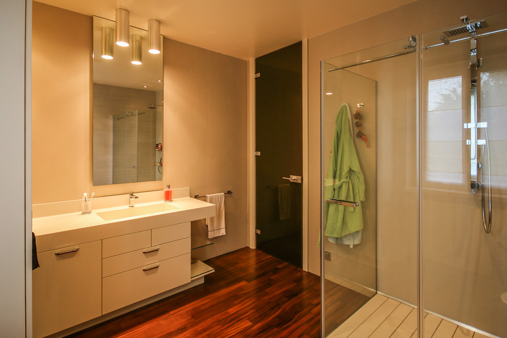 Inspiration för ett funkis en-suite badrum, med en dubbeldusch, beige kakel, keramikplattor, beige väggar och mörkt trägolv